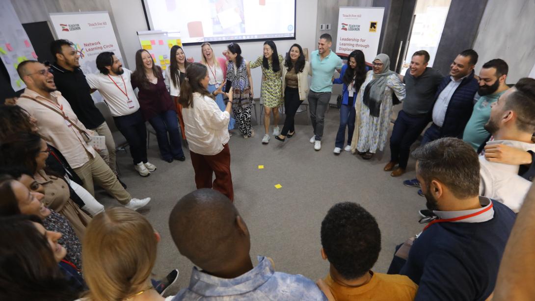 People stand in a circle with their arms around each other