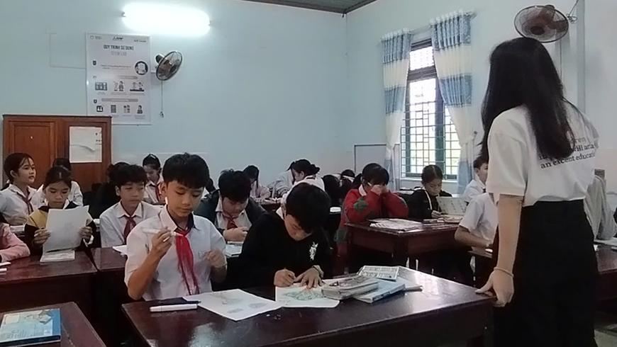 A female teacher stands in front of a classroom of primary students in Vietnam